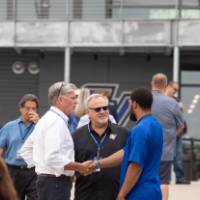 Guests shaking hands standing in a group at the Jamie Hosford Football Center dedication.